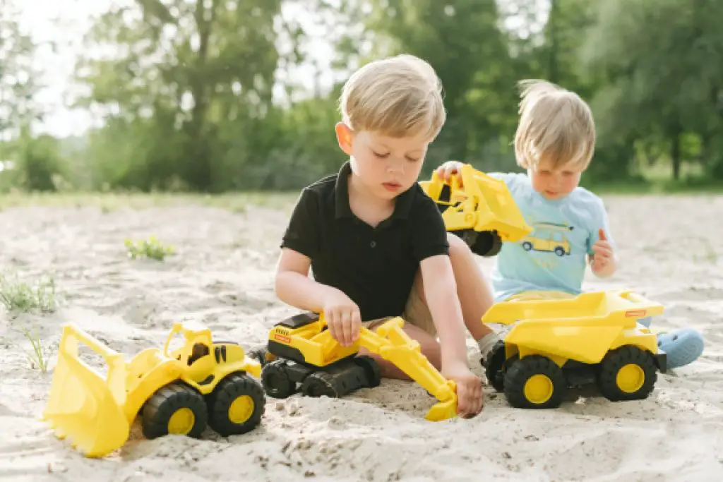children playing with construction vehicle toys