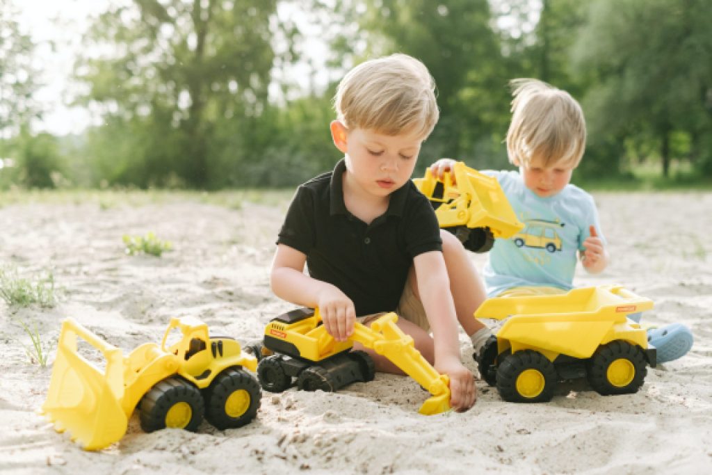 children playing with construction vehicle toys